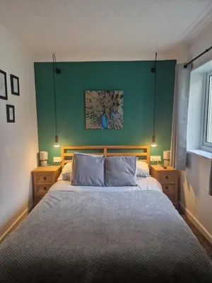 a bedroom with a large bed with a green wall at Cosy Self Contained Annexe in Bodmin