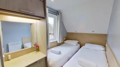 two beds in a small room with a mirror at 23 Trevithick Court, Tolroy Manor in Hayle