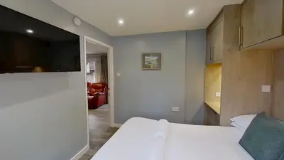 a bedroom with a bed and a flat screen tv at 23 Trevithick Court, Tolroy Manor in Hayle