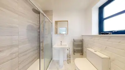 a white bathroom with a sink and a shower at 05 Queensway Gardens, Hayle in Hayle