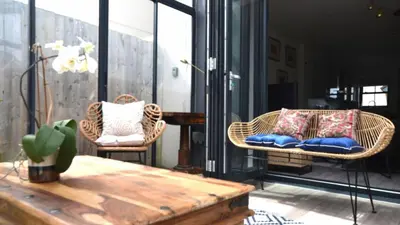 a patio with wicker chairs and a wooden table at 05 Queensway Gardens, Hayle in Hayle