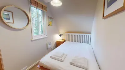 a small bedroom with a bed and a mirror at 34 Trevithick Court, Tolroy Manor in Hayle