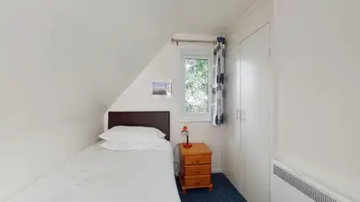 a small bedroom with a bed and a window at 37 Trevithick Court, Tolroy Manor in Hayle