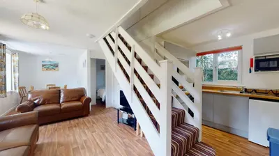 a living room with a staircase and a couch at 37 Trevithick Court, Tolroy Manor in Hayle