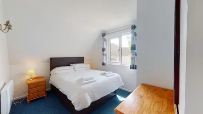 a small bedroom with a bed and a window at 37 Trevithick Court, Tolroy Manor in Hayle