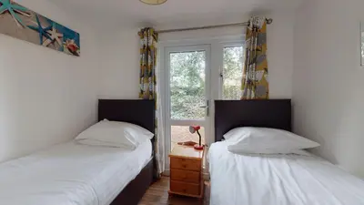 two twin beds in a room with a window at 37 Trevithick Court, Tolroy Manor in Hayle