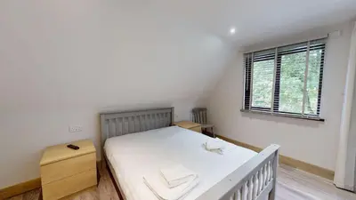 a bedroom with a white bed and a window at 48 Trevithick Court, Tolroy Manor in Hayle