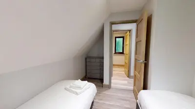a attic bedroom with two beds and a hallway at 48 Trevithick Court, Tolroy Manor in Hayle