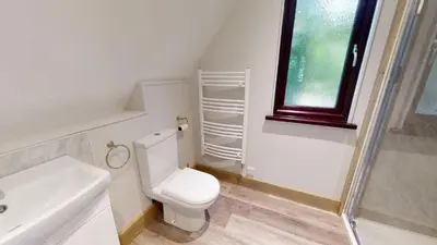 a bathroom with a toilet and a sink and a window at 48 Trevithick Court, Tolroy Manor in Hayle