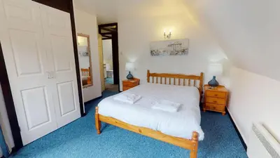 a bedroom with a bed and a white door at 15 Tudor Court, Tolroy Manor in Hayle