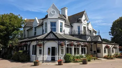 a large white house with flowers in front of it at 01 Tudor Court, Tolroy Manor in Hayle