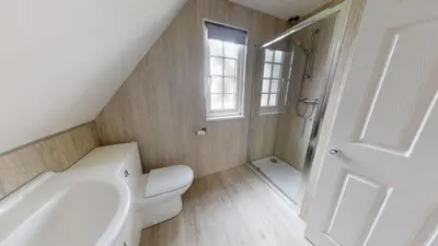 a white bathroom with a toilet and a shower at 25 Tudor Court, Tolroy Manor in Hayle