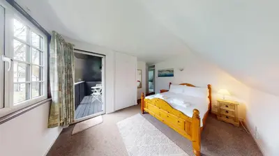 a bedroom with a bed and a large window at 25 Tudor Court, Tolroy Manor in Hayle