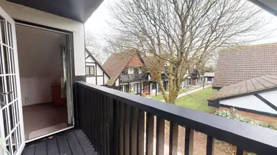 a balcony with a door open to a yard at 25 Tudor Court, Tolroy Manor in Hayle