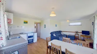 a kitchen and a living room with a table at D01 Vale Vue D1, Riviere Towans in Hayle