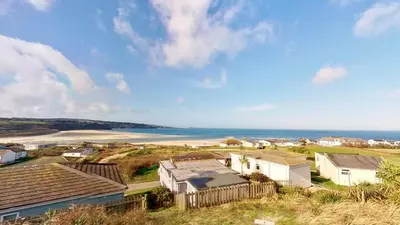 an aerial view of a town with the ocean at D14 Ridgeway, Riviere Towans in Hayle