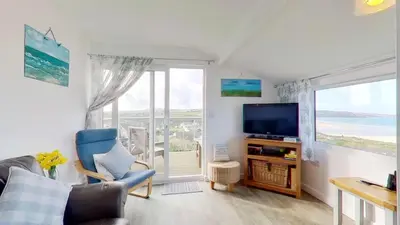 a living room with a couch and a tv and a window at D14 Ridgeway, Riviere Towans in Hayle