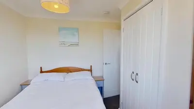 a bedroom with a bed with a wooden head board at D20 Glendon, Riviere Towans in Hayle