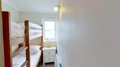 a bedroom with two bunk beds and a mirror at D29 Westbourne, Riviere Towans in Hayle