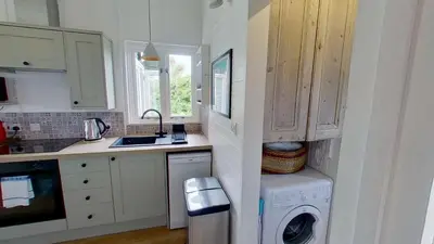 a kitchen with a washer and dryer in it at D04 Hawaiian D4, Riviere Towans in Hayle