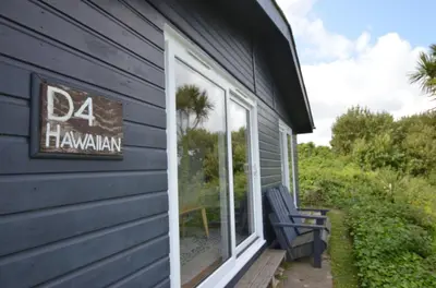 a blue house with a sign on the side of it at D04 Hawaiian D4, Riviere Towans in Hayle
