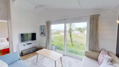 a living room with a tv and a large window at D04 Hawaiian D4, Riviere Towans in Hayle