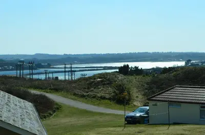 a car parked next to a road next to a house at D06 Heloan D6, Riviere Towans in Hayle