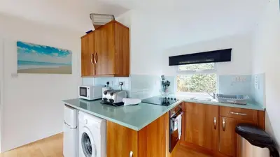 a kitchen with a sink and a microwave at D06 Heloan D6, Riviere Towans in Hayle