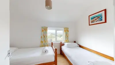two twin beds in a room with a window at D06 Heloan D6, Riviere Towans in Hayle