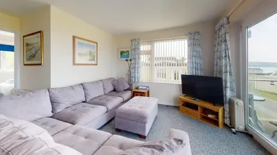 a living room with a large couch and a tv at D32 Chyanvean, Riviere Towans in Hayle