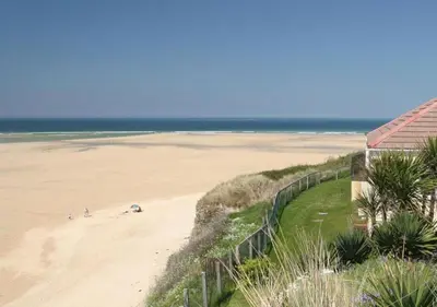 a view of a beach with a fence and the ocean at D32 Chyanvean, Riviere Towans in Hayle