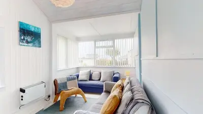 a living room with a blue couch in a room at D34 Homeleigh, Riviere Towans in Hayle
