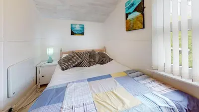 a bedroom with a bed in a white room at D34 Homeleigh, Riviere Towans in Hayle