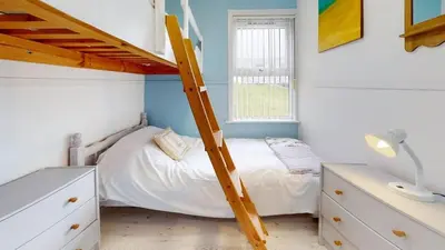 a bedroom with a bunk bed with a ladder at D34 Homeleigh, Riviere Towans in Hayle