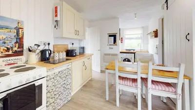 a kitchen with a table and chairs in a kitchen at D34 Homeleigh, Riviere Towans in Hayle