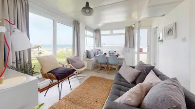a living room with a couch and chairs and a table at D45 Medina, Riviere Towans in Hayle