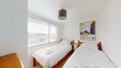 two beds in a small room with a window at D45 Medina, Riviere Towans in Hayle
