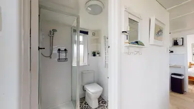 a white bathroom with a toilet and a shower at D45 Medina, Riviere Towans in Hayle