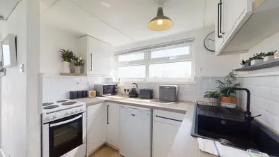 a white kitchen with a stove and a sink at D45 Medina, Riviere Towans in Hayle