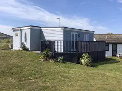 a small house with a fence in a yard at D44 Pendarves, Riviere Towans in Hayle
