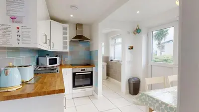 a kitchen with white cabinets and a counter top at D44 Pendarves, Riviere Towans in Hayle