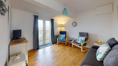 a living room with a couch and a table and chairs at D44 Pendarves, Riviere Towans in Hayle