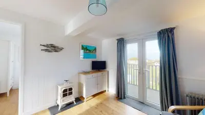 a living room with a tv and a window at D44 Pendarves, Riviere Towans in Hayle