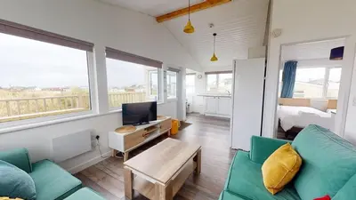 a living room with a couch and a tv at D38 Miramar, Riviere Towans in Hayle