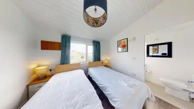 a bedroom with a large bed and a sink at D38 Miramar, Riviere Towans in Hayle