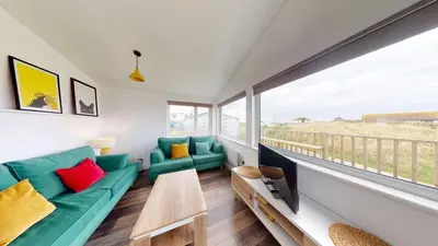 a living room with a couch and a tv at D38 Miramar, Riviere Towans in Hayle