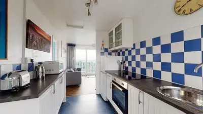 a kitchen with blue and white tiles on the wall at D39 St Margarets, Riviere Towans in Hayle