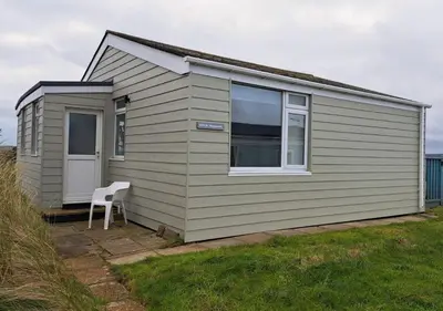 a small house with a white chair in front of it at D39 St Margarets, Riviere Towans in Hayle