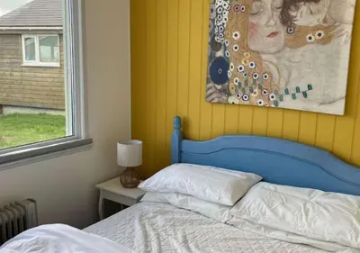 a bed with a blue head board in a bedroom at D39 St Margarets, Riviere Towans in Hayle