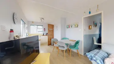 a kitchen and a living room with a table and chairs at D50 Ocean Swell, Riviere Towans in Hayle